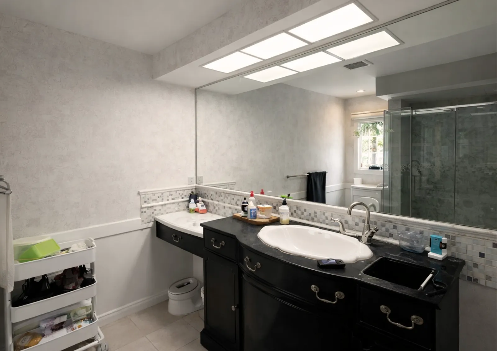 Bathroom before, with a dark single vanity