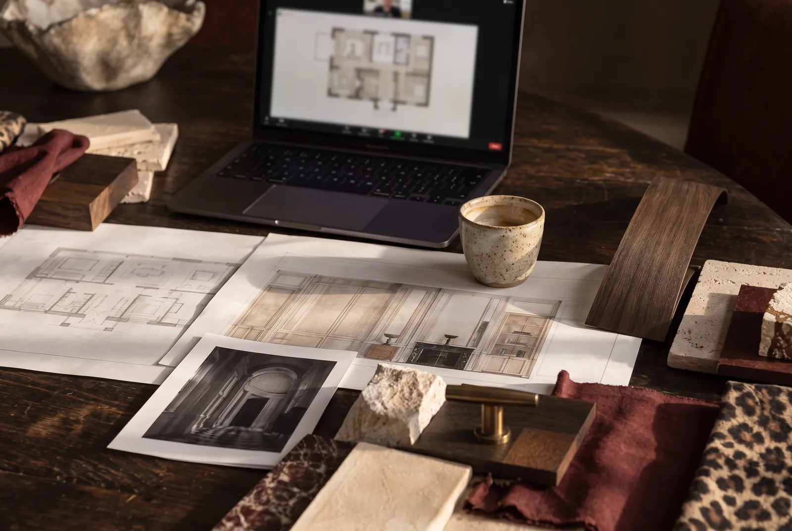 Laptop on a video call beside printed drawings